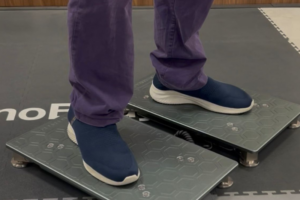 Atleta esegue un test di salto su una piattaforma dinamometrica in un contesto di riabilitazione sportiva.